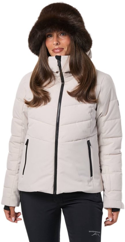 Vrouw draagt een beige ski-jas en een donkerbruine bontmuts.