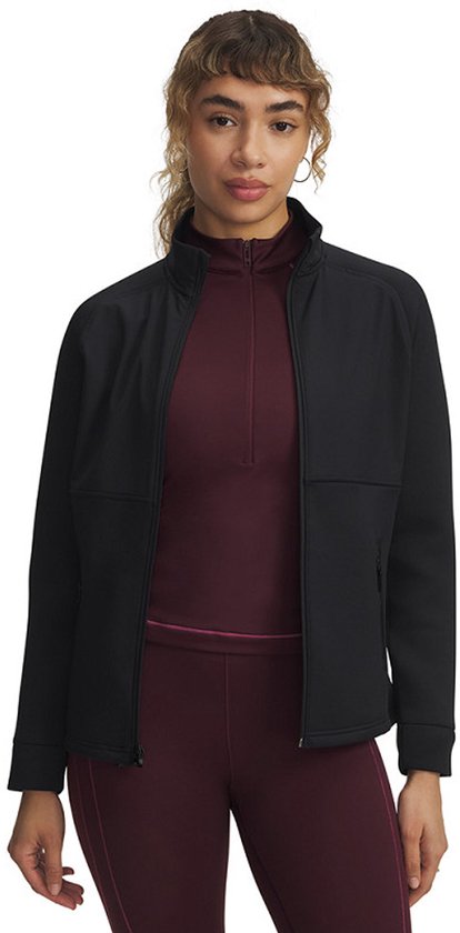 Model draagt een zwart sportjack met rits over een donkerrode top met halve rits en bijpassende legging.