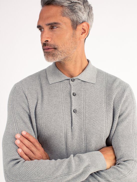 Close-up van de grijze polo met textuur, verticale strepen en knoopsluiting.
