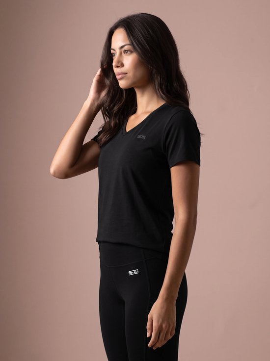 Vrouw in zwart sportshirt met V-hals en logo op de borst.