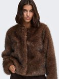 Model met kort haar draagt een donkerbruin imitatiebont jack zonder kraag.