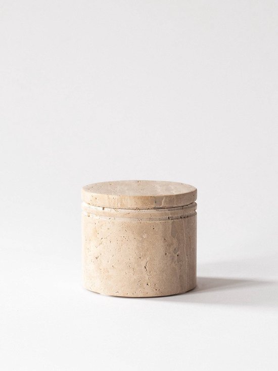 Cilindrische pot van beige travertijn met een bijpassend deksel, staand op een witte ondergrond.