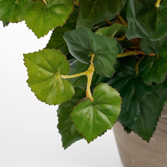Une plante artificielle avec des feuilles vertes et un pot rayé marron.
