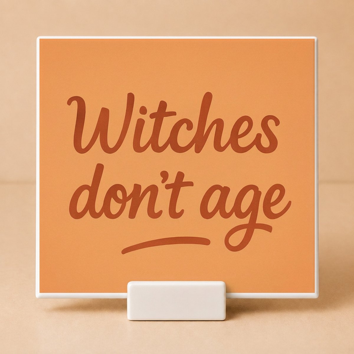 Tegeltje met Spreuk "Witches Don't Age" Oranje – Keramisch Tegeltje 11x11 cm met Houdertje – Grappig Verjaardagscadeau