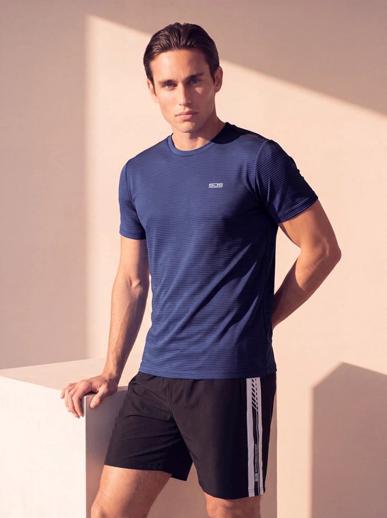 Man draagt een donkerblauw gestreept sportshirt met logo en zwarte sportbroek met witte bies.