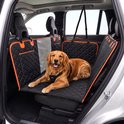 Golden Retriever avec harnais sur une couverture pour chien noire avec bordure orange, allongé sur la banquette arrière d'une voiture.