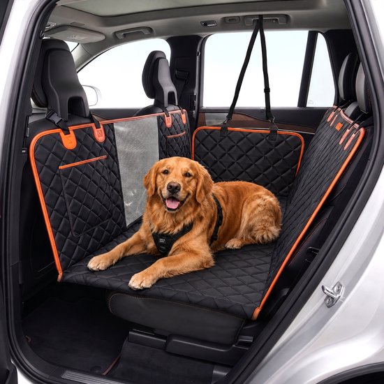 Golden Retriever avec harnais sur une couverture pour chien noire avec bordure orange, allongé sur la banquette arrière d'une voiture.