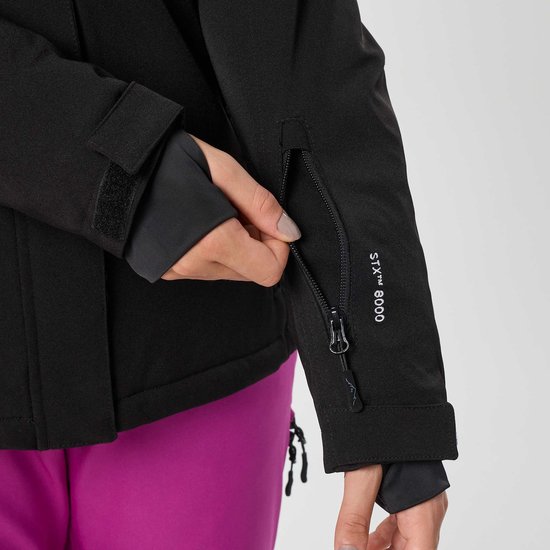 Vrouw sluit de rits van een zak op de mouw van haar zwarte ski-jas.