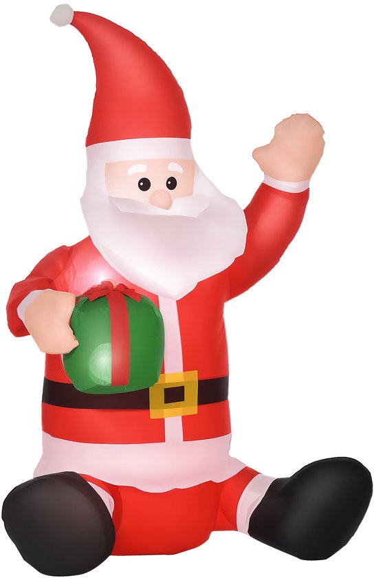 Zittende opblaasbare Kerstman in rood kostuum met een groen cadeau in zijn hand, zwaaiend.