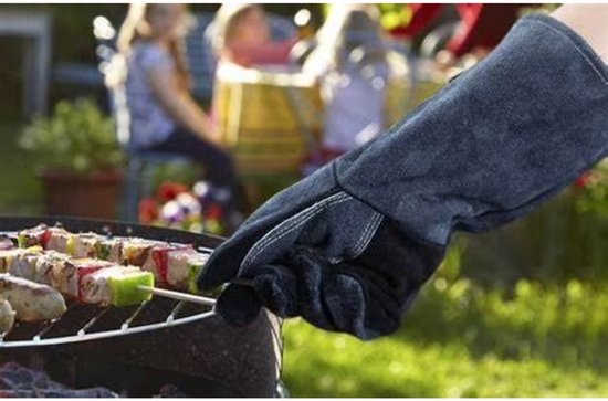 Hand in grijze suède handschoen met lange schacht gebruikt bij het grillen van spiesjes.