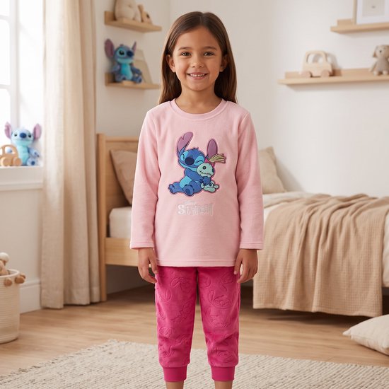 Lachend kind in roze Stitch fleece pyjamaset met lange mouwen en Stitch-motief.