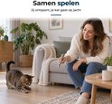 Vrouw speelt in een woonkamer met haar kat met een zilverkleurige LECTRIK laserpen met rode lichtstip.