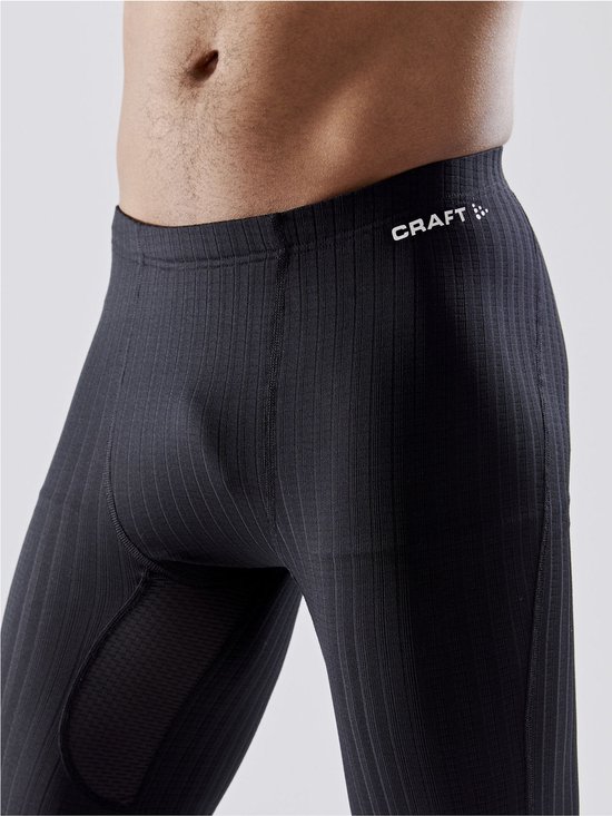 Detail van zwarte thermobroek met ribbelstructuur, mesh-inzetstukken en Craft-logo op de heup.