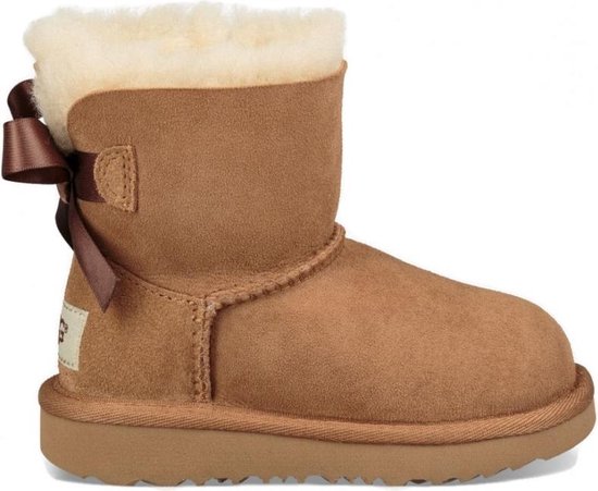 Cognackleurige suède kinderlaars met witte schapenvacht voering en strik aan de achterkant.