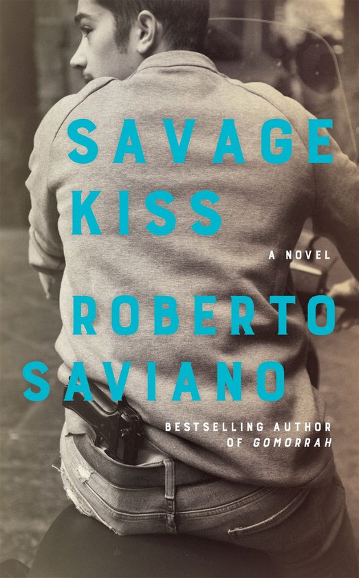Boekomslag met de titel "Savage Kiss" in blauwe letters. Een man draagt een grijze trui en jeans met een pistool in zijn achterzak.