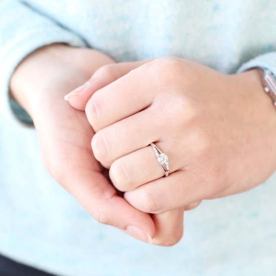 Dames handen met een zilverkleurige ring met zirkonia.