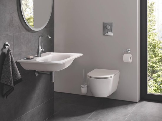 Salle de bain minimaliste avec WC suspendu, porte-brosse WC mural et lavabo.
