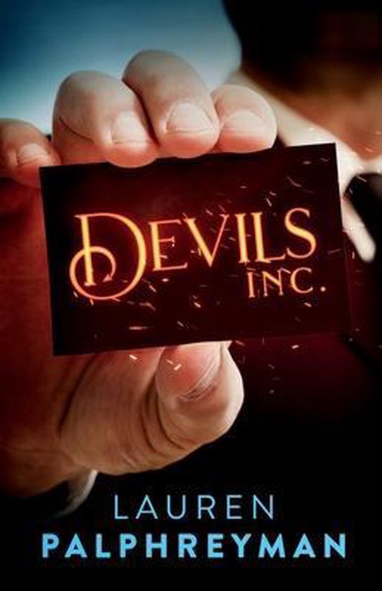 Une main tient une carte de visite avec le texte "Devils Inc." en lettres orange incandescentes. Le nom de l'auteur, "Lauren Palphreyman", est en bas.