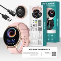 Roze FITAGE smartwatch met gouden details, inclusief laadkabel en verpakking. Toont "04:30 WED 04/06".