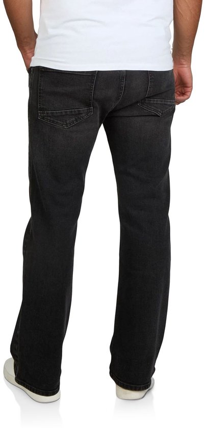 Man met handen in zakken, draagt een zwarte bootcut spijkerbroek van Riverso.