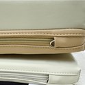 Beige en lichtgroene foam matten opgestapeld met een open rits.
