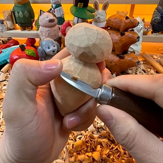 Een gedetailleerde close-up van een persoon die met een mes een houten figuur snijdt, met achtergrond van gesneden hout en houten beelden.