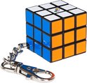 Rubik's Cube sleutelhanger met blauwe, witte en oranje vlakken zichtbaar.