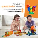 Deux enfants jouent joyeusement avec des tuiles magnétiques colorées, construisant diverses structures sur le sol.
