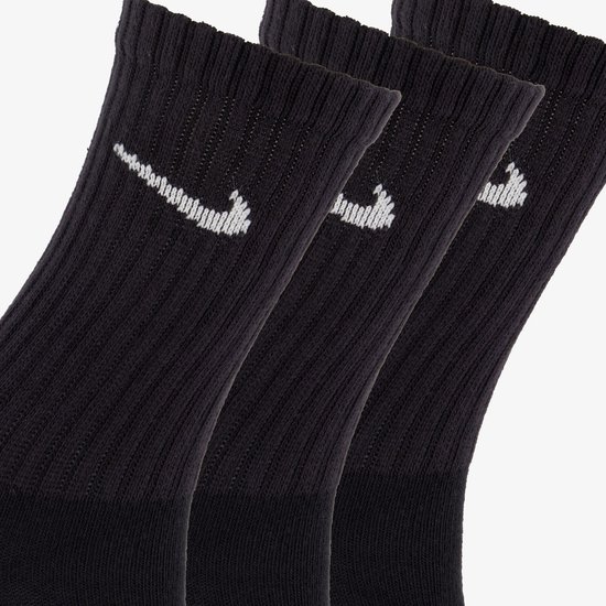 Drie zwarte sportsokken met witte Nike 'swoosh' logo's.