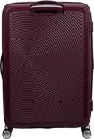 Burgondische koffer met cirkelvormig patroon, handvat aan de bovenzijde en vier wielen. 'American Tourister' logo op de voorkant.