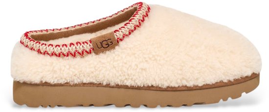 Beige Ugg-slipper met een witte en rode gebreide rand, bruine zool en Ugg-logo.