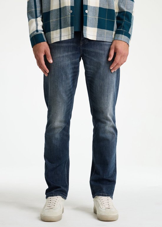 Man met donkerblauwe spijkerbroek met een relaxte pasvorm, van voren gezien, met wit met blauwe geruite blouse.