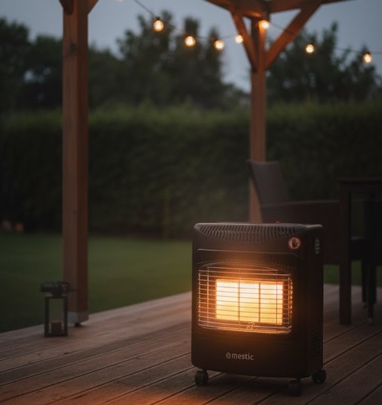 Zwarte Mestic mobiele gaskachel met gloeiend rooster op een houten terras, 's avonds.