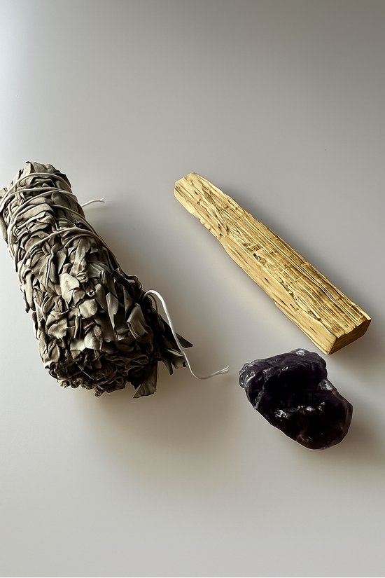 Bundel witte salie, een stuk palo santo hout en een ruwe amethist kristal.