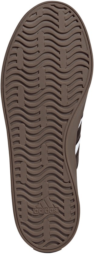 Bruine rubberen zool van een sneaker met een golvend profiel en een adidas-logo bij de hiel.