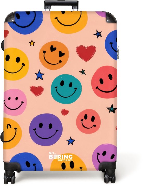 Grote koffer met een patroon van kleurrijke smiley's, harten en sterren op een perzikkleurige achtergrond.