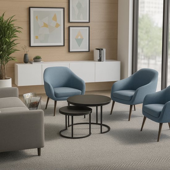Zwarte ronde salontafelset van 2 in een zithoek met blauwe fauteuils en een grijze bank.