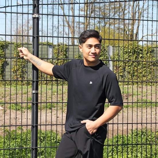 Man met tattoo op de arm, draagt een zwart sportshirt met korte mouwen.