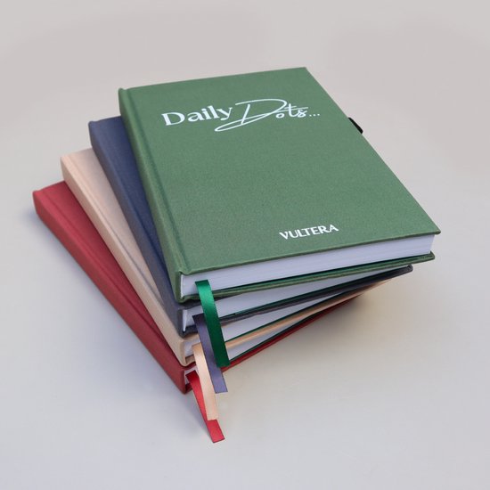 Stapel dagboeken in groen, blauw, beige en rood, met linten in verschillende kleuren.