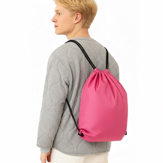 Man draagt een roze gymtas met trekkoord op zijn rug. De tas is gevuld en hangt losjes om zijn schouder.