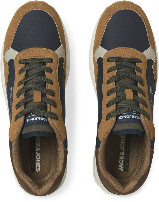 Topview van een paar donkerblauwe sneakers met suède bruine, beige en groene panelen. Groene veters.
