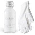 Een witte fles 'Calma Cosmetics Body Lotion' met een zilveren dop en een witte handschoen ernaast.