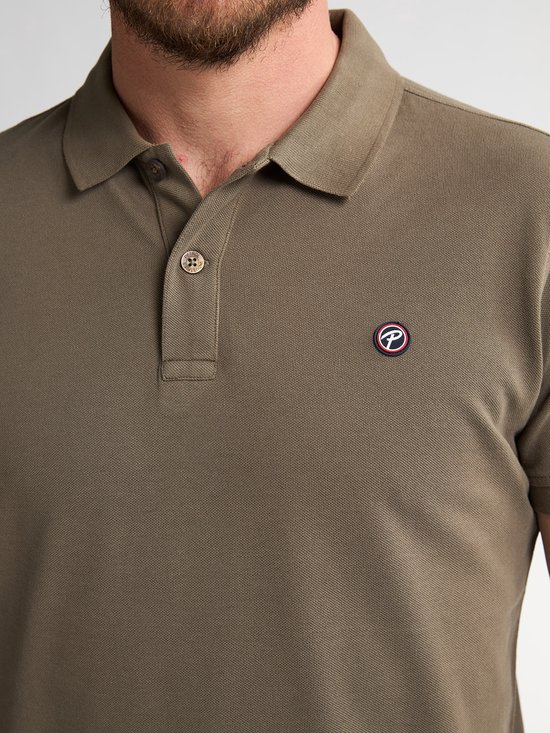 Close-up van een olijfgroen poloshirt met knoopsluiting en Petrol Industries logo op de borst.