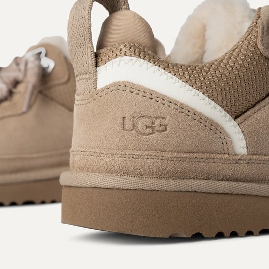 Detail van beige UGG sneaker met UGG logo op de zijkant.