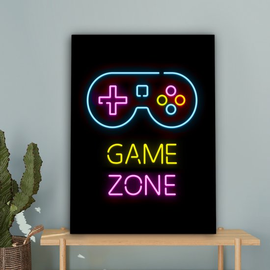 Toile noire avec néons : manette bleue, texte jaune 'GAME', texte rose 'ZONE', près d'une table à cactus.