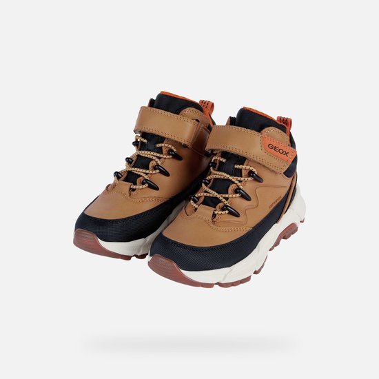 Een paar bruine halfhoge schoenen met zwarte en oranje details, veters en klittenband.