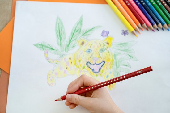 Close-up van een kind dat een rode Bic Kids potlood gebruikt om een tekening van een jaguar af te maken.