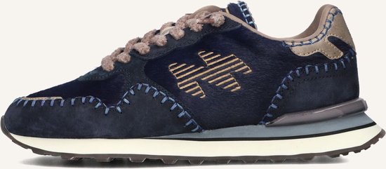 Baskets bleu marine avec lacets beiges, détails logo et coutures apparentes. Mélange de textures daim et poilues.