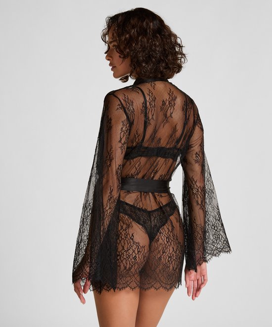 Model van achteren gezien in zwarte kanten kimono met satijnen ceintuur.