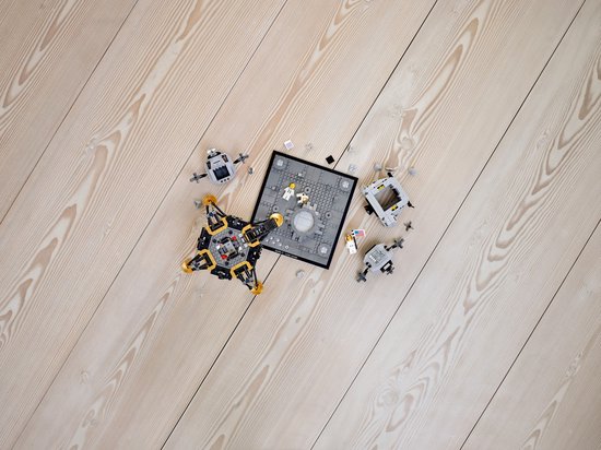 LEGO Maanlander en onderdelen verspreid op houten vloer.